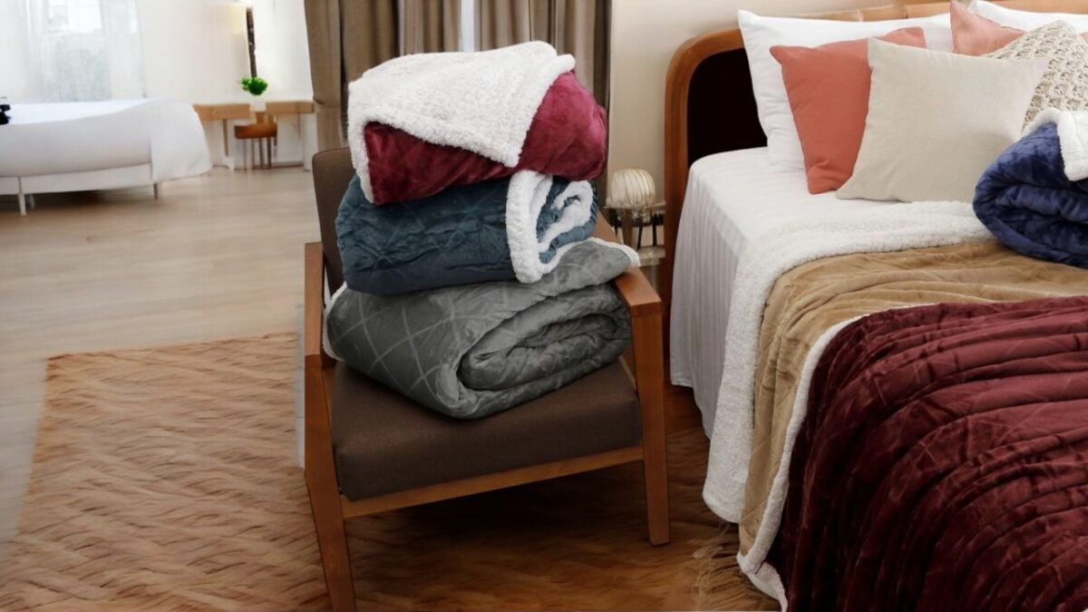 a comforter on a luxurious bed, with an indoor living room in the background